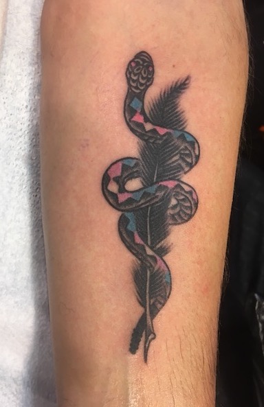tattoo of writing quill with rattlesnake wrapped around it with a blue-pink-white-pink-blue diamond pattern