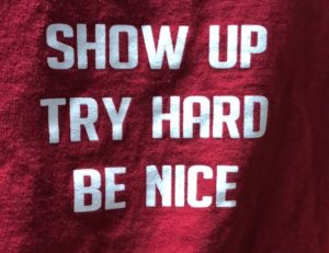 Tee shirt saying "show up, try hard, be nice"