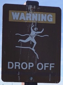 a warning sign showing that the shallow water drops off quickly to deep water