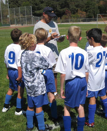 Peter coaching a youth team in 2008, several kids looking up at him
