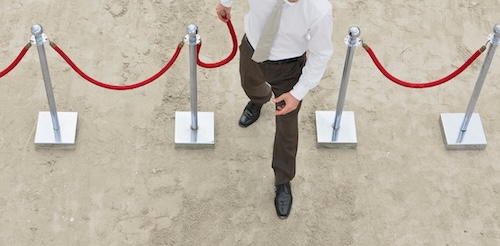 A businessman violates personal boundaries by disconnecting the rope from the stanchion and walking right through