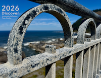 It's almost 2026. Here's the cover of the 2026 calendar. A view of the Oregon coast as seen through a rusty arch in a bride handrail.