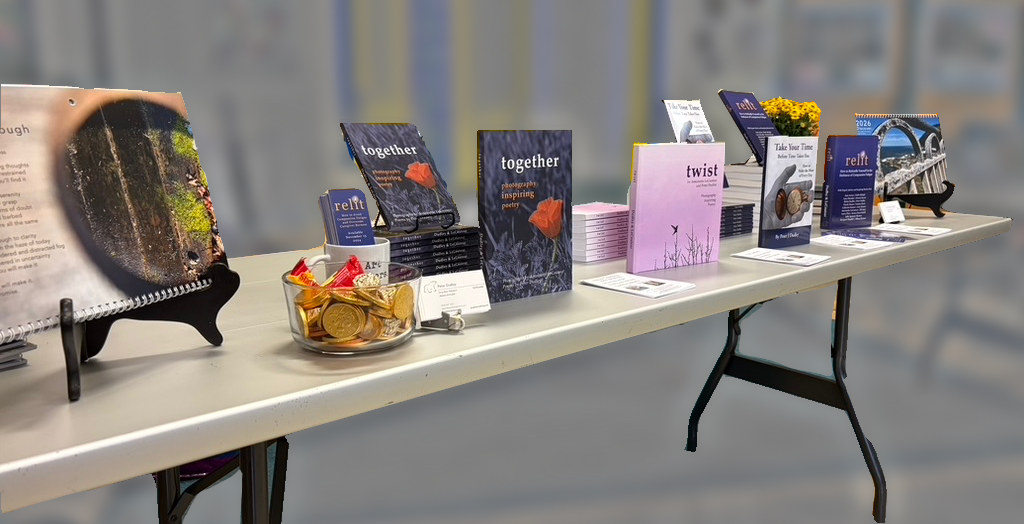 Books, calendars, and branded merchandise arrayed along a table with a blurred background