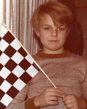 Peter's younger self, about 9 years old, holds a checkered flag